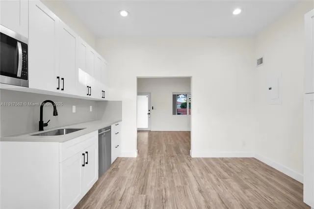 a kitchen with a sink cabinets and wooden floor