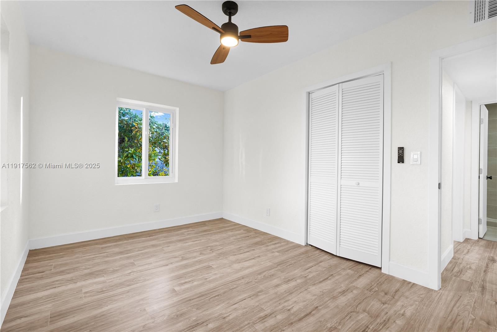 88 Southwest 29th Avenue Miami, FL 33135 - Photo 13 of 30 an empty room with wooden floor ceiling fan and windows
