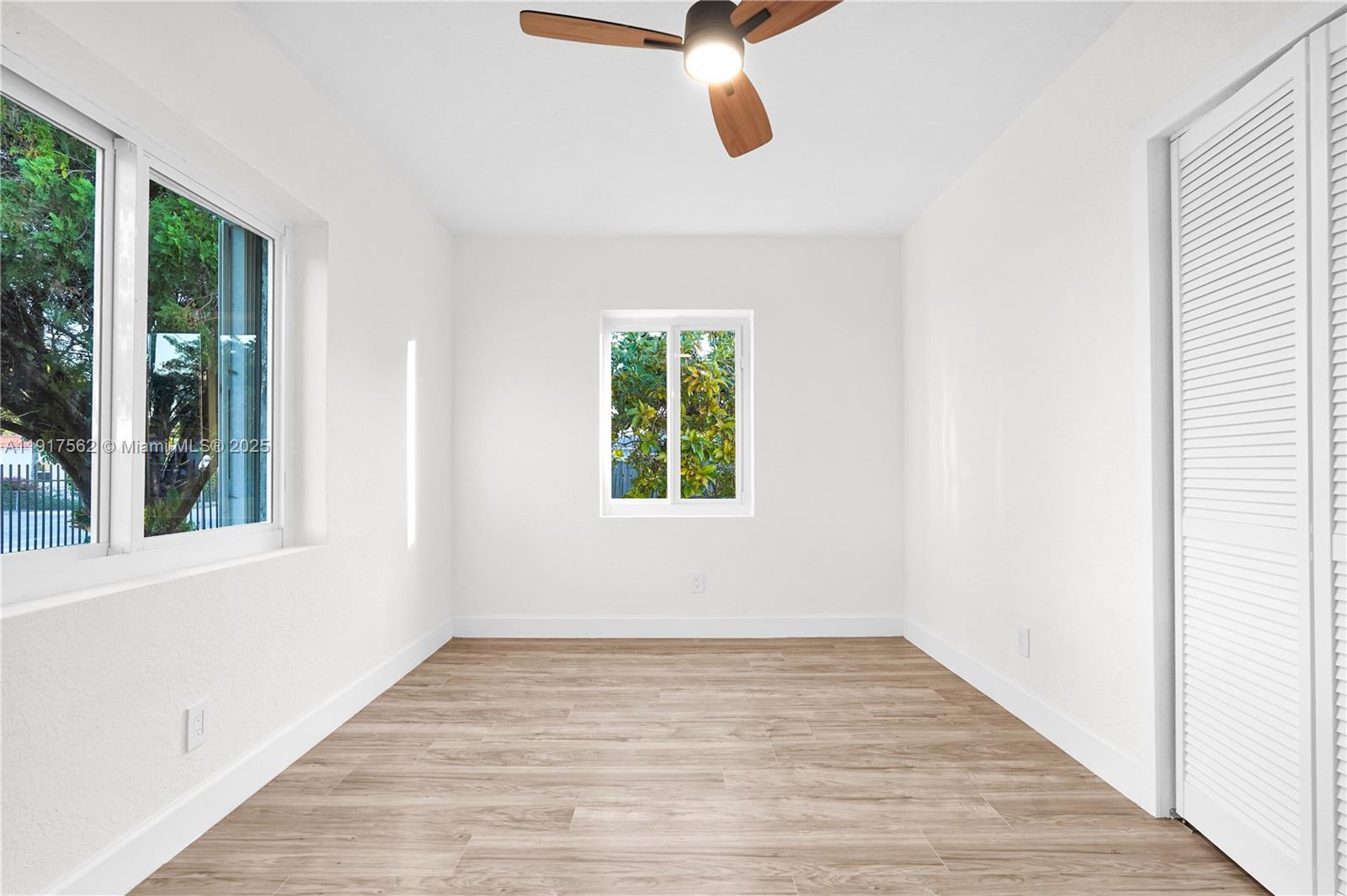 88 Southwest 29th Avenue Miami, FL 33135 - Photo 14 of 30 a view of an empty room with wooden floor and windows