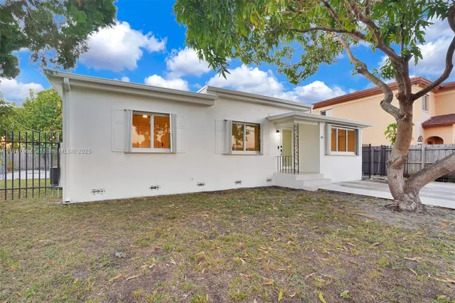 a view of a house with a tree and a yard