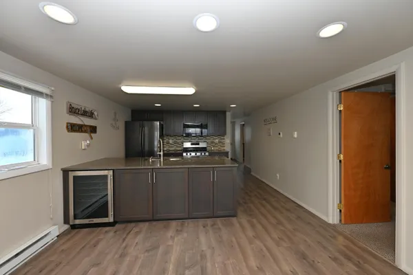 a kitchen with stainless steel appliances granite countertop a sink cabinets and wooden floor