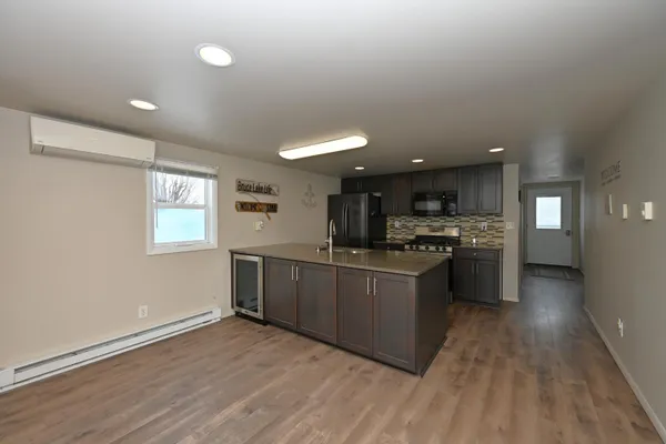 a kitchen with stainless steel appliances kitchen island granite countertop a stove a sink and a refrigerator