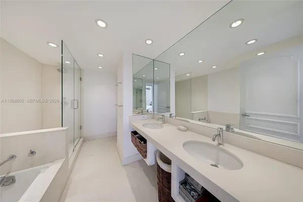 a spacious bathroom with a double vanity sink a mirror and a bathtub
