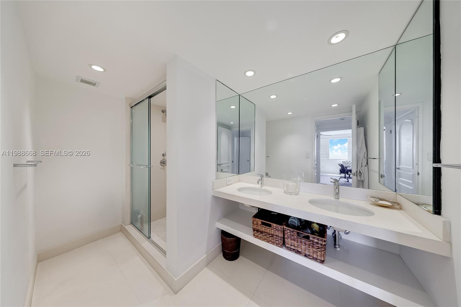 200 Ocean Ln Drive, Unit 1102 Key Biscayne, FL 33149 - Photo 14 of 24 a bathroom with a double vanity sink a large mirror and shower
