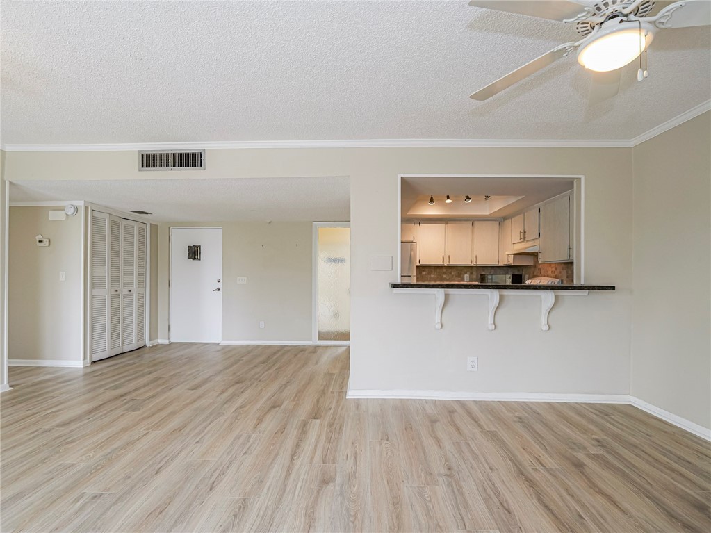 1860 Robalo Drive, Unit A105 Vero Beach, FL 32960 - Photo 7 of 35 a view of a room with wooden floor and a large mirror