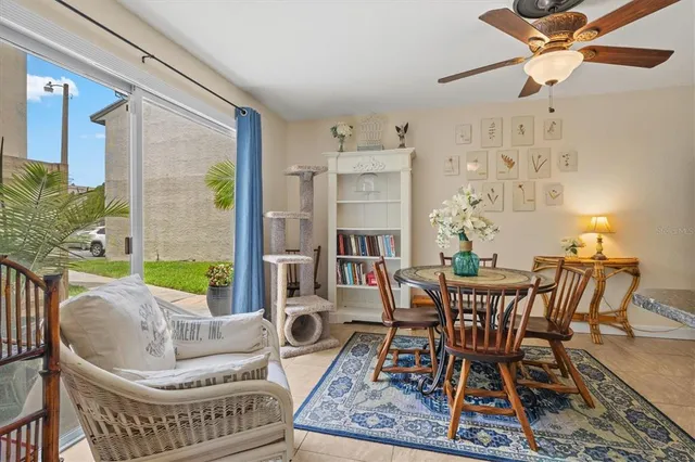 a kitchen with stainless steel appliances granite countertop a refrigerator a stove a sink a dining table and chairs with wooden floor