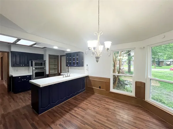 a large kitchen with kitchen island a large island in the center and stainless steel appliances