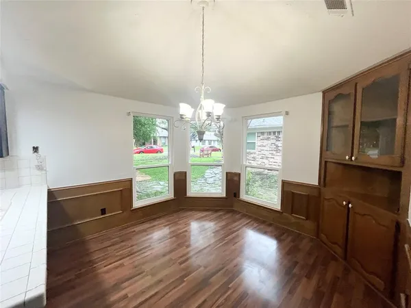 a view of a kitchen with wooden floor electronic appliances and furniture
