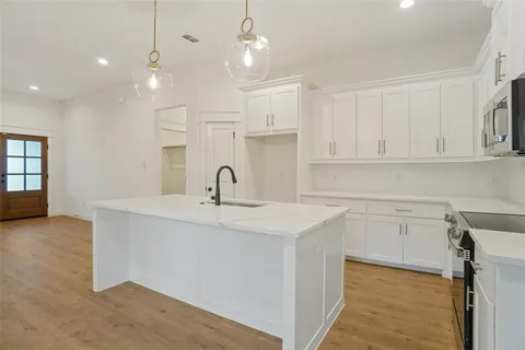 a kitchen with white cabinets appliances and a sink
