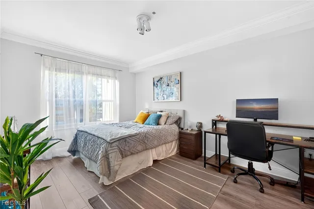 a bedroom with a bed table chair and a window