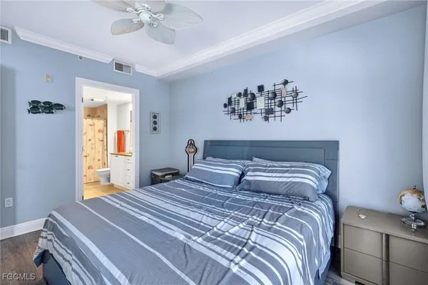 a bedroom with a large bed and a chandelier