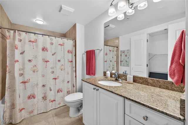 a bathroom with a granite countertop sink a toilet and a large mirror