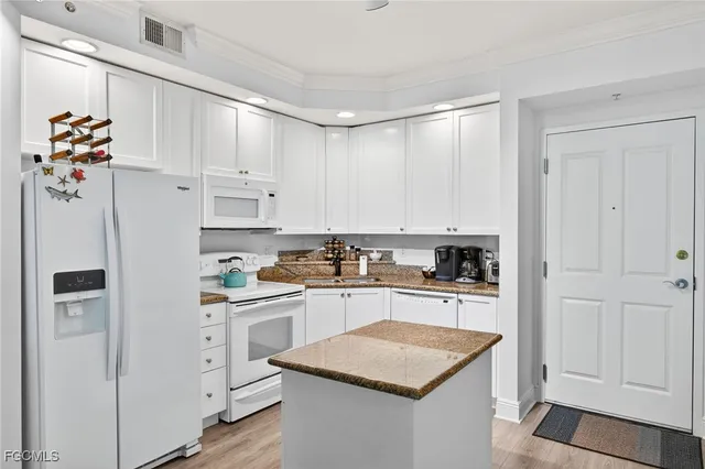 a kitchen with white cabinets and appliances