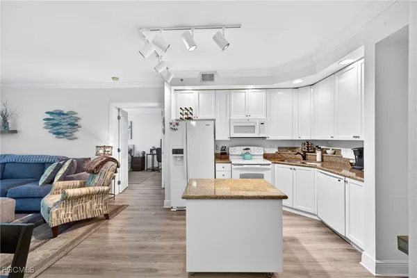 a kitchen with stainless steel appliances granite countertop a refrigerator and a stove top oven