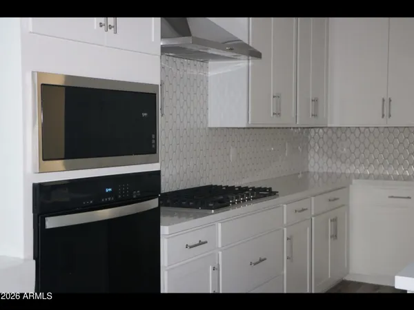 a kitchen with granite countertop white cabinets and black appliances