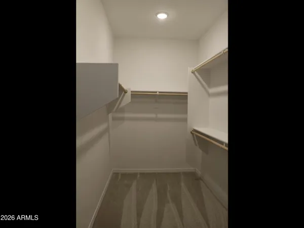a view of walk in closet with clothes