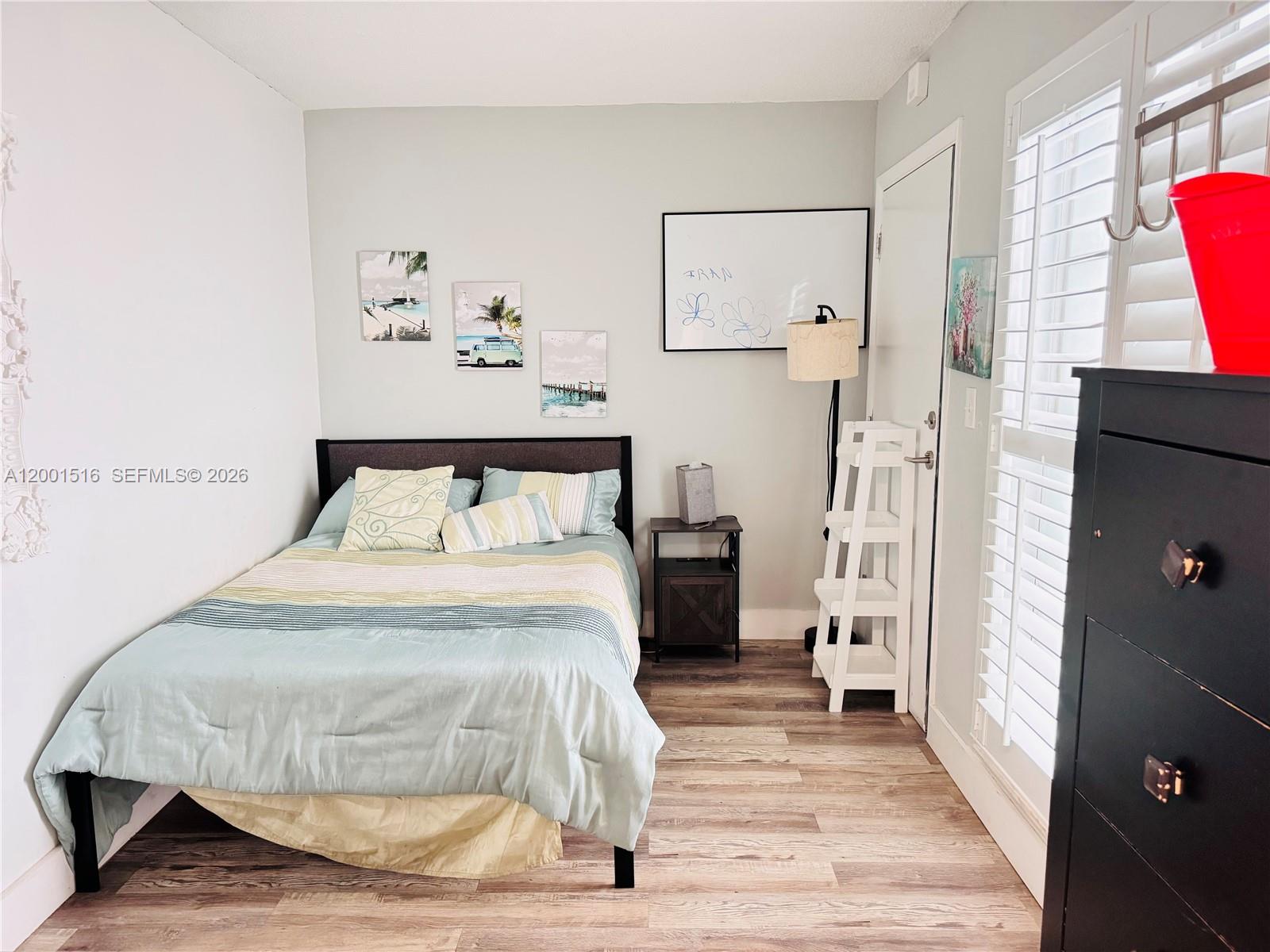 1340 Lincoln Road, Unit 805 Miami Beach, FL 33139 - Photo 18 of 21 a bedroom with a bed and wooden floor