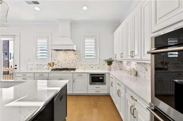 a kitchen with stainless steel appliances granite countertop a sink stove and cabinets