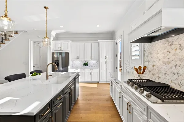 a kitchen with stainless steel appliances granite countertop a sink stove and cabinets