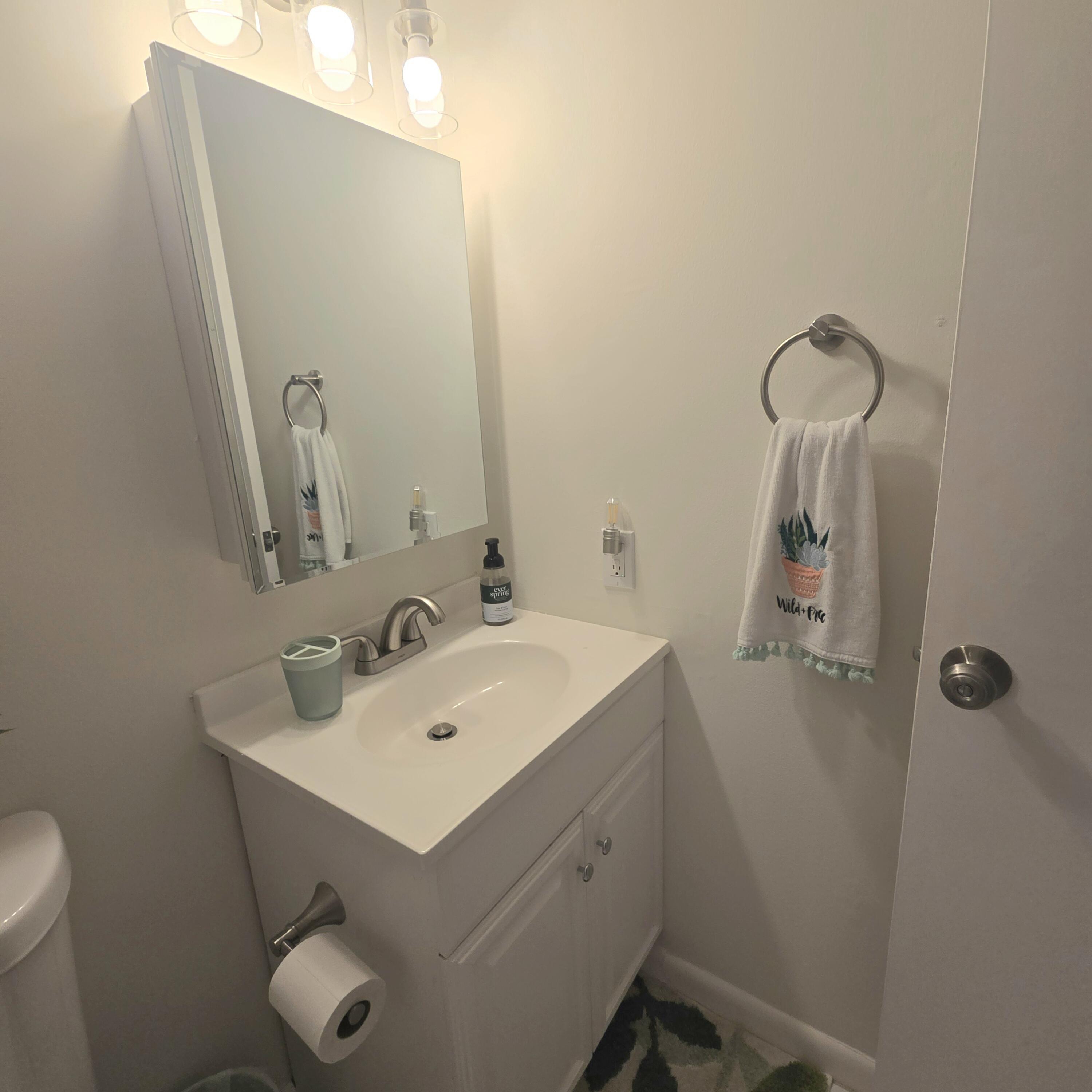 1967 Southwest Palm City Road, Unit 34C Stuart, FL 34994 - Photo 13 of 25 a bathroom with a sink mirror and toilet