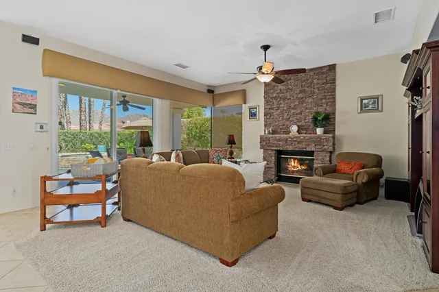 a living room with furniture a fireplace and a large window