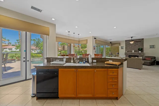a dining hall with stainless steel appliances granite countertop a stove and a sink