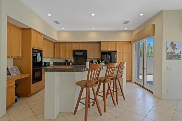 a kitchen with stainless steel appliances kitchen island granite countertop a refrigerator and microwave