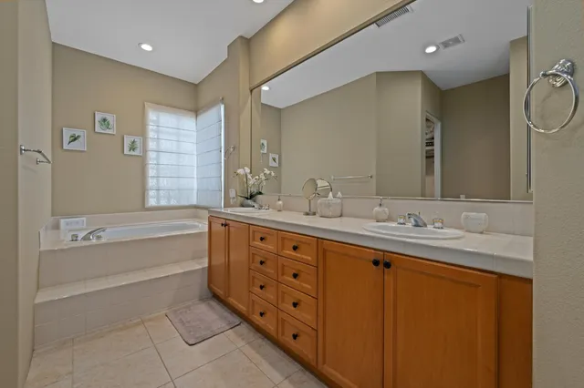 a bathroom with double vanity sink and a bathtub