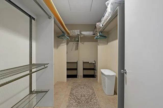 a view of walk in closet with clothes and shoes