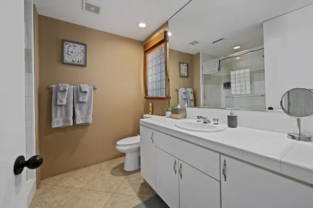 a bathroom with a toilet sink and mirror