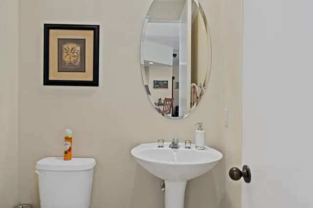 a bathroom with a sink mirror and toilet