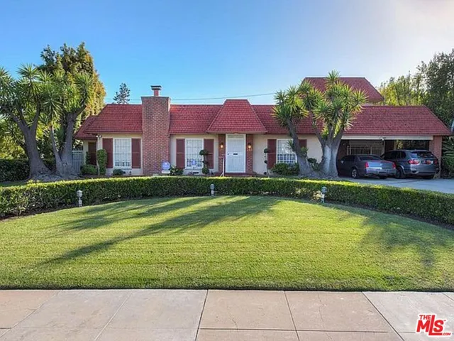 a aerial view of a house with a garden and lake view