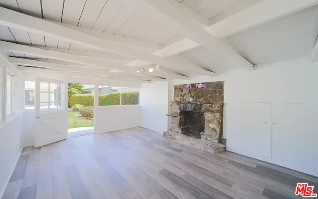 a white bed sitting in a bedroom next to a window