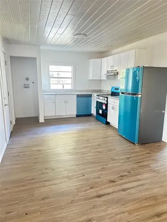 a view of a kitchen with wooden floor and electronic appliances