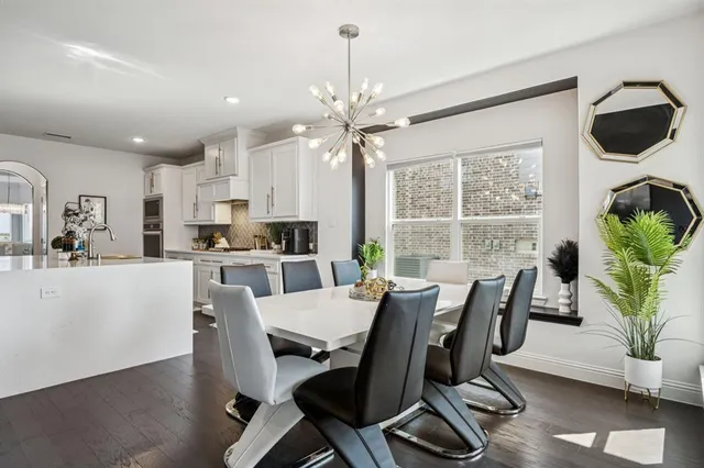 a dining room with furniture a chandelier and wooden floor