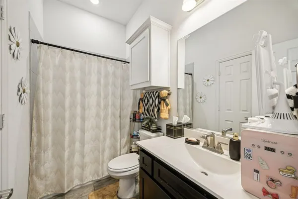 a bathroom with a sink a toilet and shower curtain