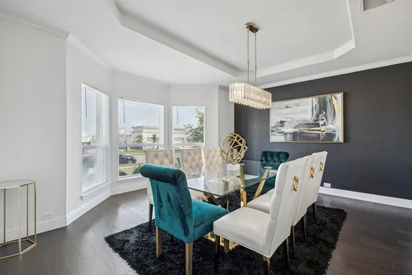 a dining room with furniture a chandelier and wooden floor