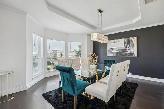 a dining room with furniture a chandelier and wooden floor