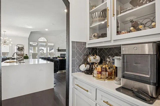 a kitchen with white cabinets and chandelier