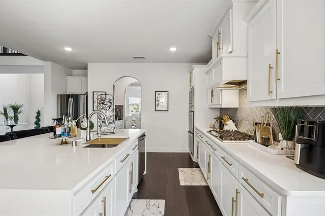 a kitchen with kitchen island white cabinets and white appliances