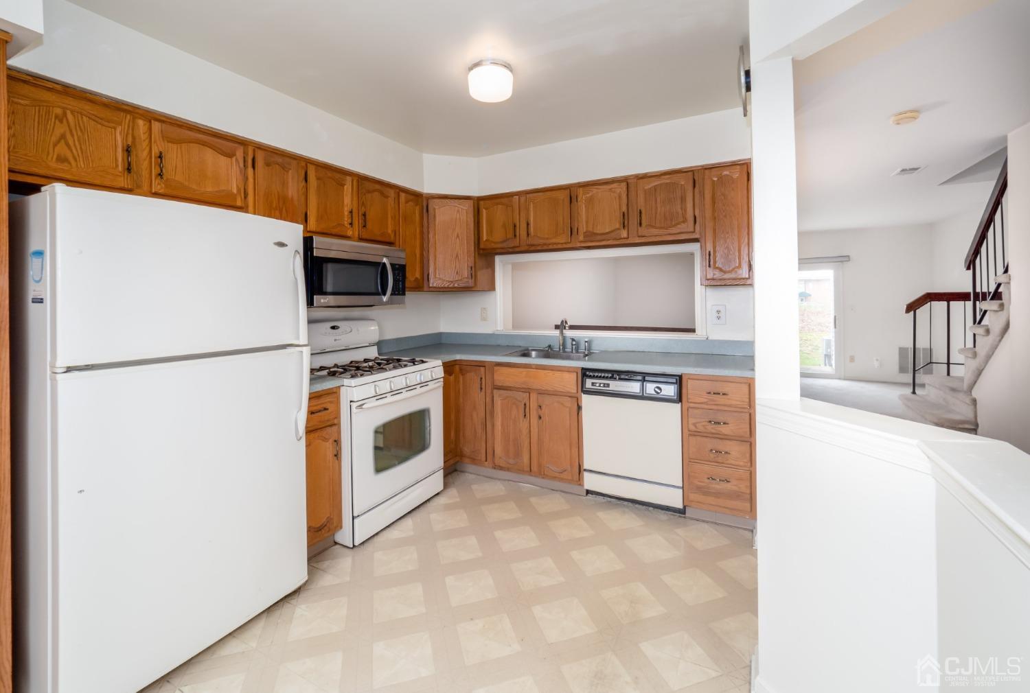 1403 Maplecrest Road Edison, NJ 08820 - Photo 5 of 23 a kitchen with stainless steel appliances white cabinets and a refrigerator