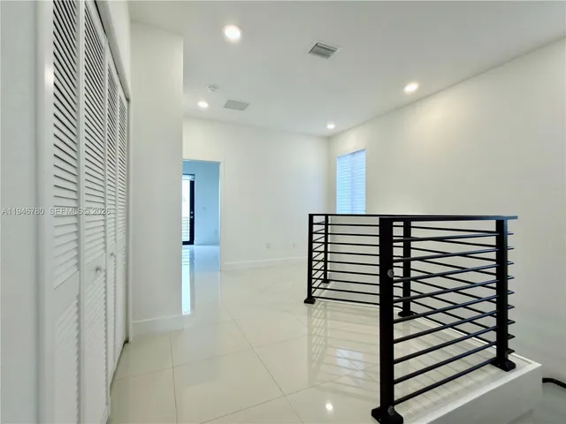 a view of a hallway with stairs and a couch