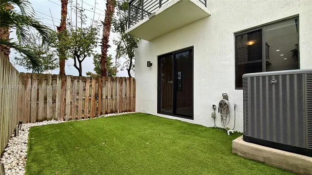 a view of a backyard with wooden fence and a large tree