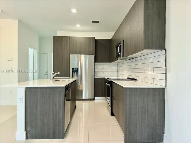 a kitchen with a sink refrigerator and cabinets