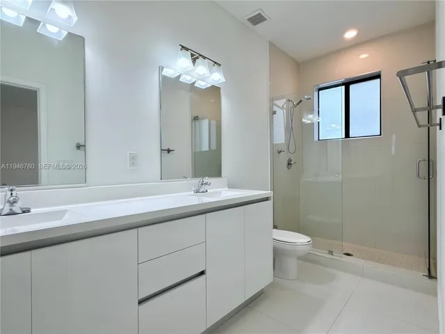 a bathroom with a double vanity sink toilet and shower