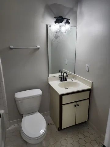 a white toilet sitting next to a bathroom sink