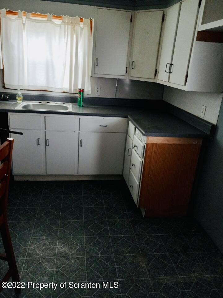 1102 Pierce Street Scranton, PA 18508 - Photo 6 of 10 a kitchen with granite countertop a sink a stove and cabinets