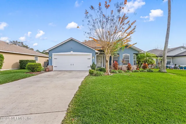 a front view of a house with a yard and garage