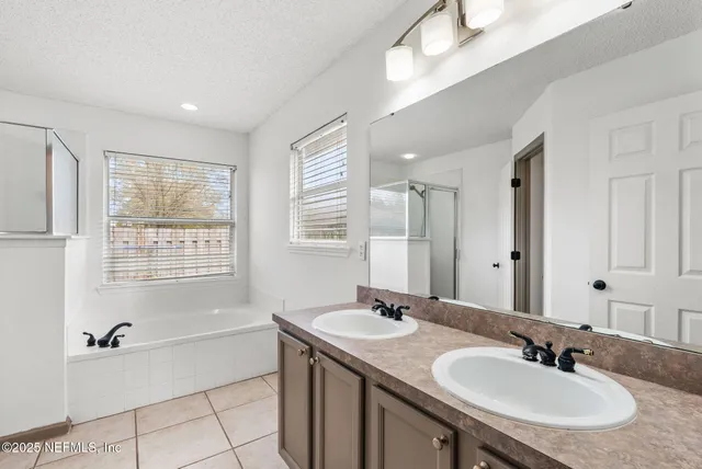 a bathroom with a granite countertop sink and a bathtub