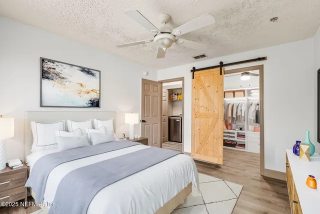 a bedroom with a large bed and a chandelier